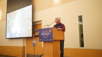 Dean Mark Stetter speaking at a podium