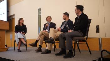 four speakers on a stage for the human rights panel