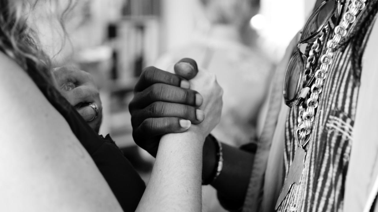black and white photo of hands clasped together
