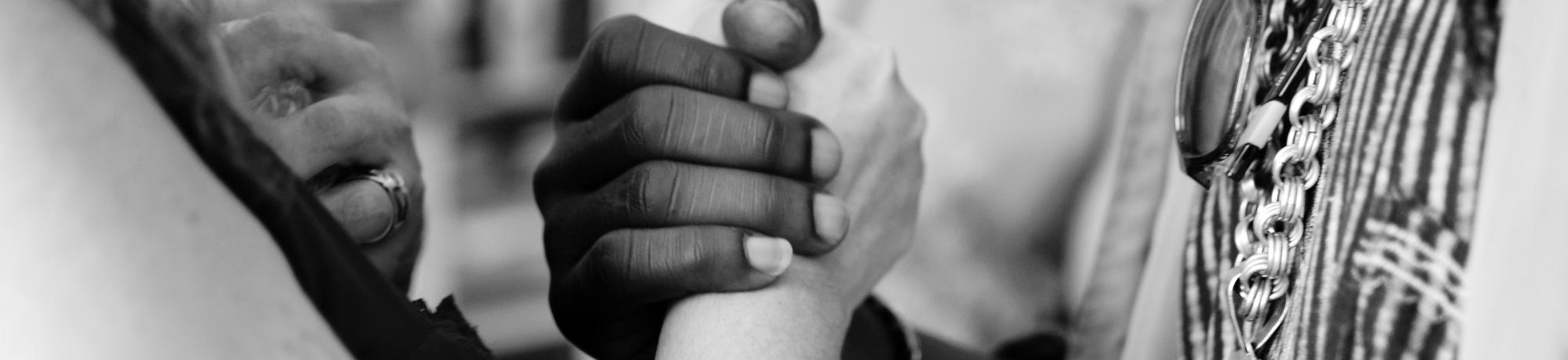 black and white photo of hands clasped together